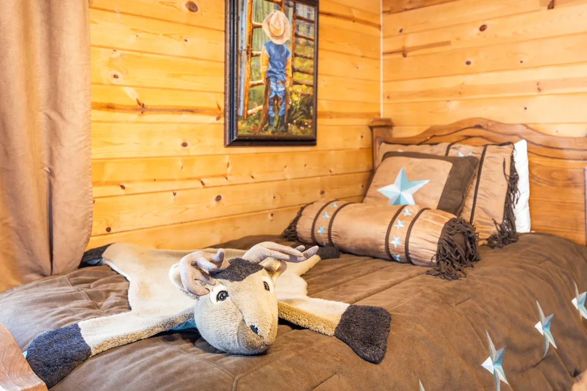 A cozy bedroom with a star-themed bedding set, a plush stuffed animal on the bed, and cheerful wall art. The inviting atmosphere is ideal for children, with soft lighting and playful touches.