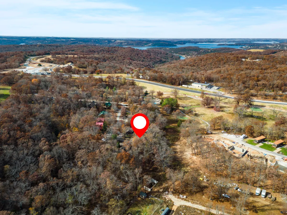 A tranquil view of dense woods, clearings, a nearby highway, and a distant lake offers a sense of peaceful immersion in nature, while proximity to infrastructure is still apparent.